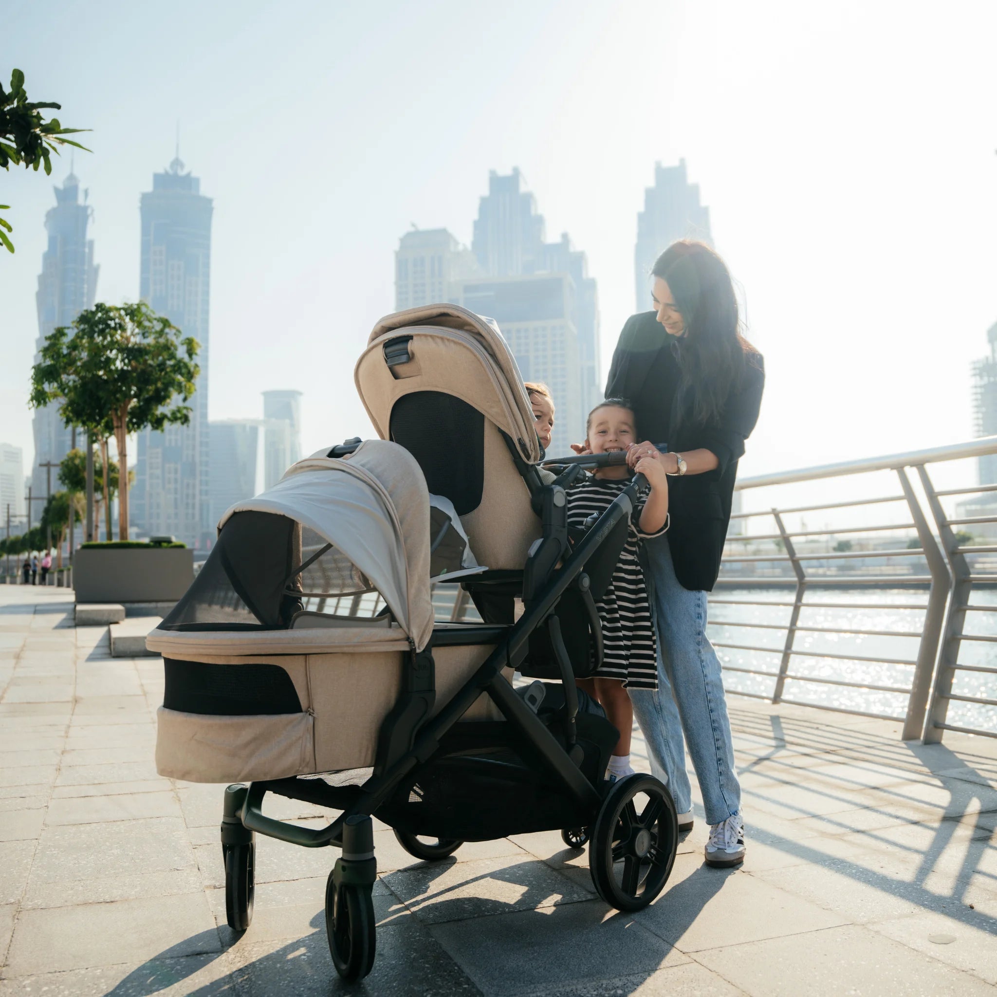 Mum pushing the Vista V3 in Liam with three children with city skyline in the background.