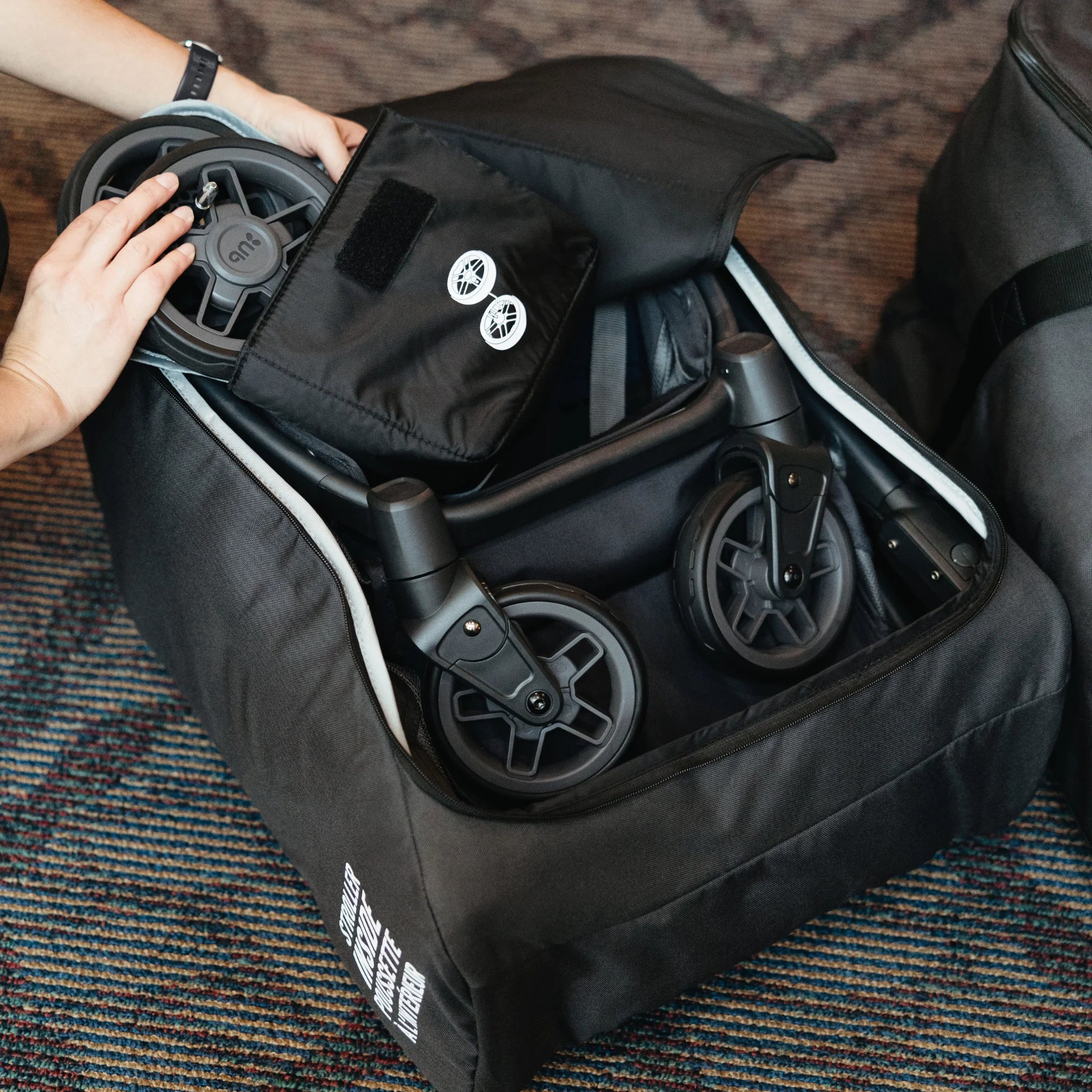 UPPAbaby Minu V3 Travel Bag with folded stroller inside, open stroller travel bag being packed