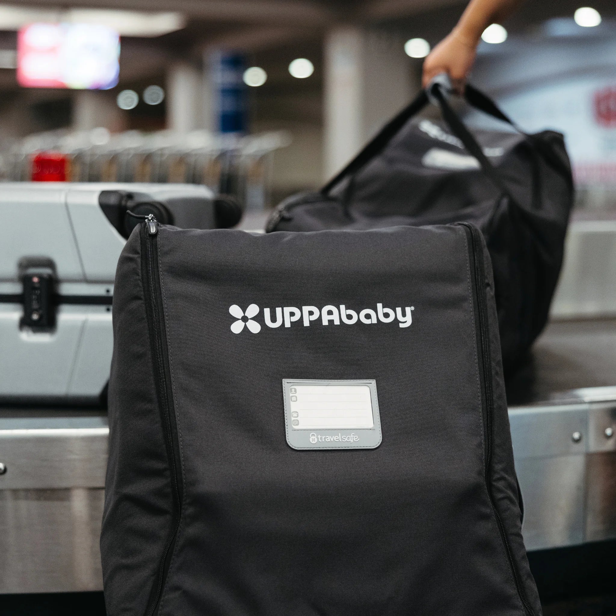 UPPAbaby Minu V3 Travel Bag at airport check-in, black stroller travel bag with logo and ID window