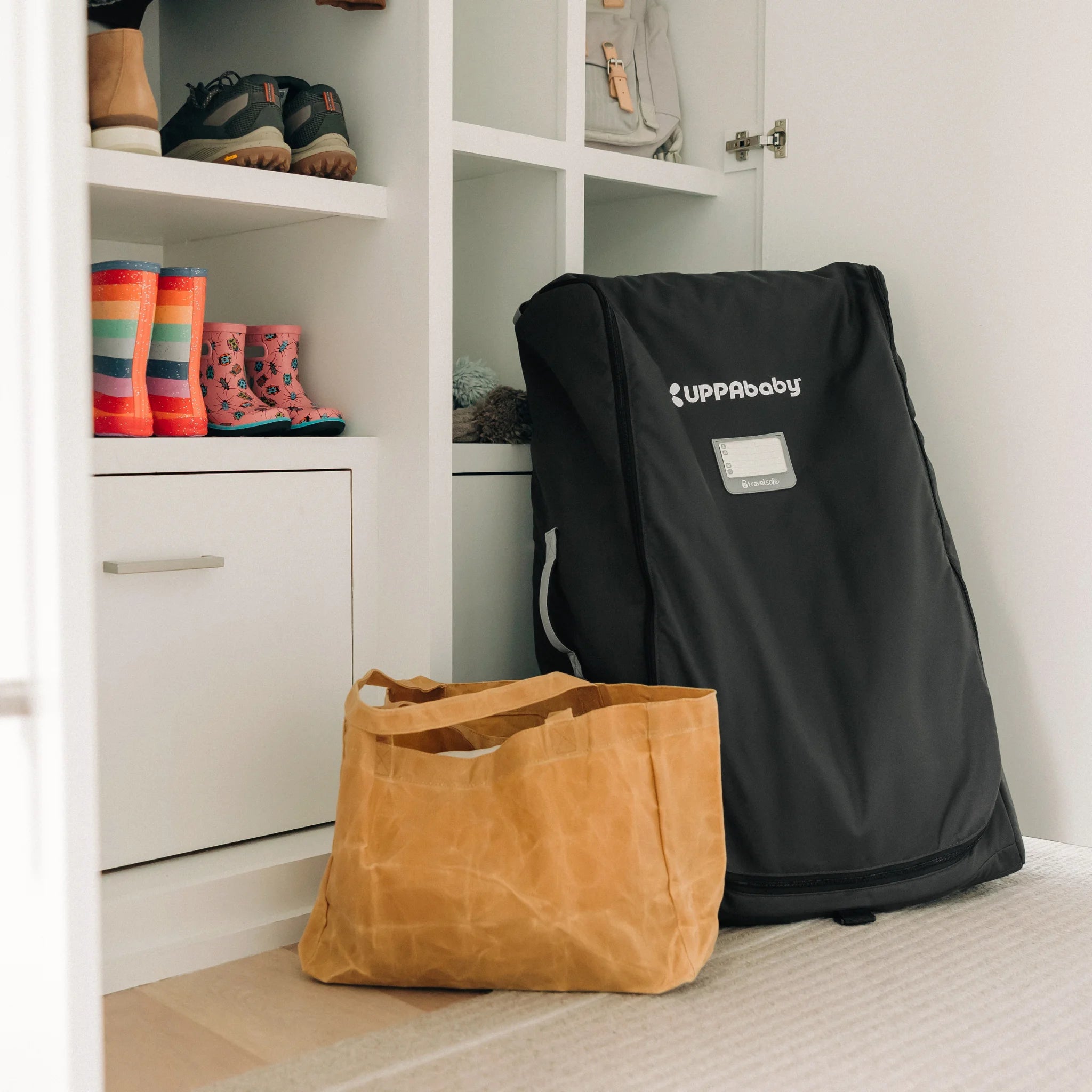 UPPAbaby Travel Bag for Vista and Cruz stroller standing in hallway, protective storage bag with logo