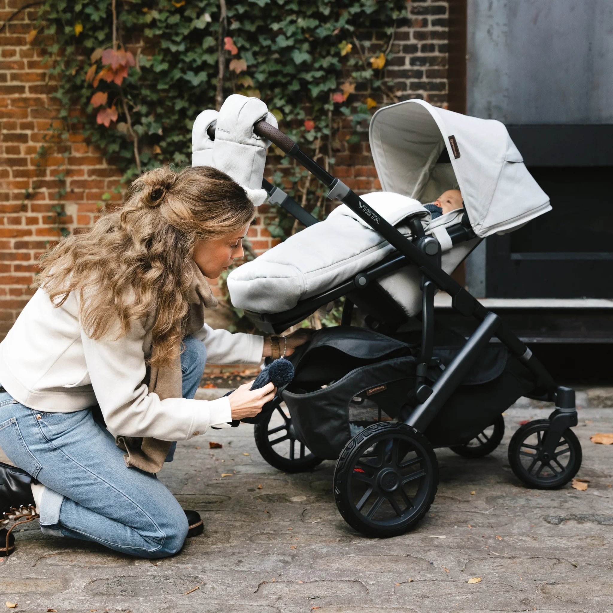 Mum taking out hat out of the bottom of the vista buggy,outside.