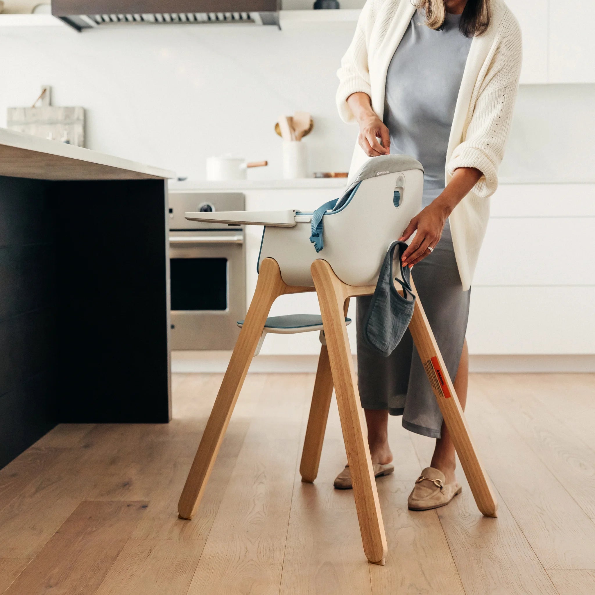 Mom cleaning high chair with high chair cushion accessory in the kitchen