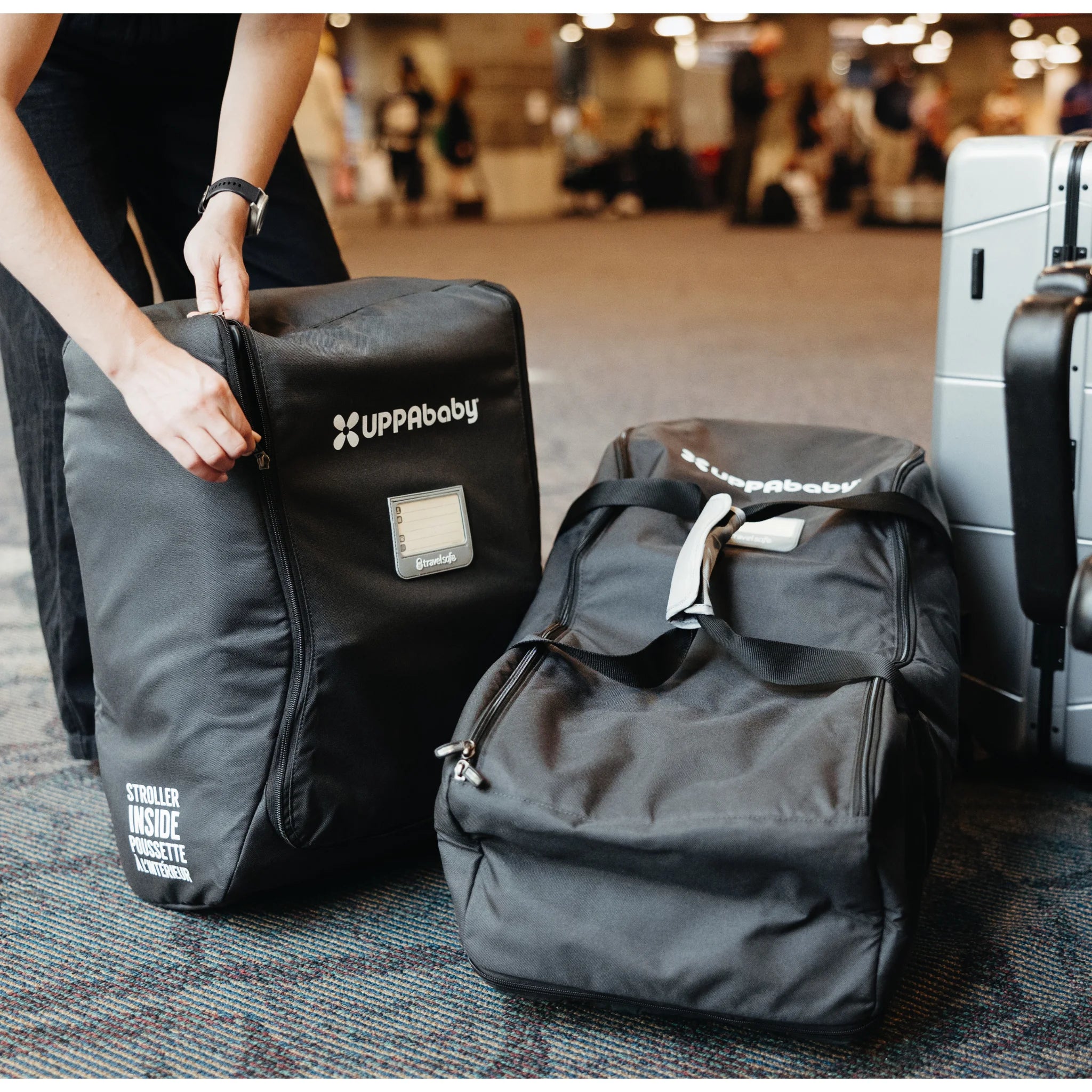 Woman zipping up mesa i-size travel bag, with the mesa i-size car seat inside.