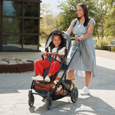 Woman pushing the Cruz V3 with a child in a park