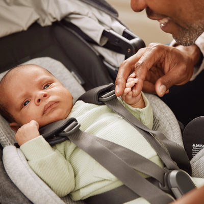 Baby in the Cruz V3 in newborn mode with dad smiling at their baby.