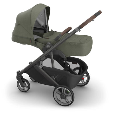 Side view of the UPPAbaby Cruz V3 stroller with the Infant Cover in Evelyn, featuring an olive green canopy and newborn-ready enclosure