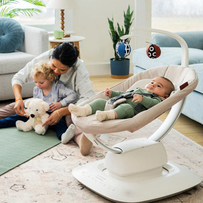 Mum and toddler doing yoga while newborn in smart swing.