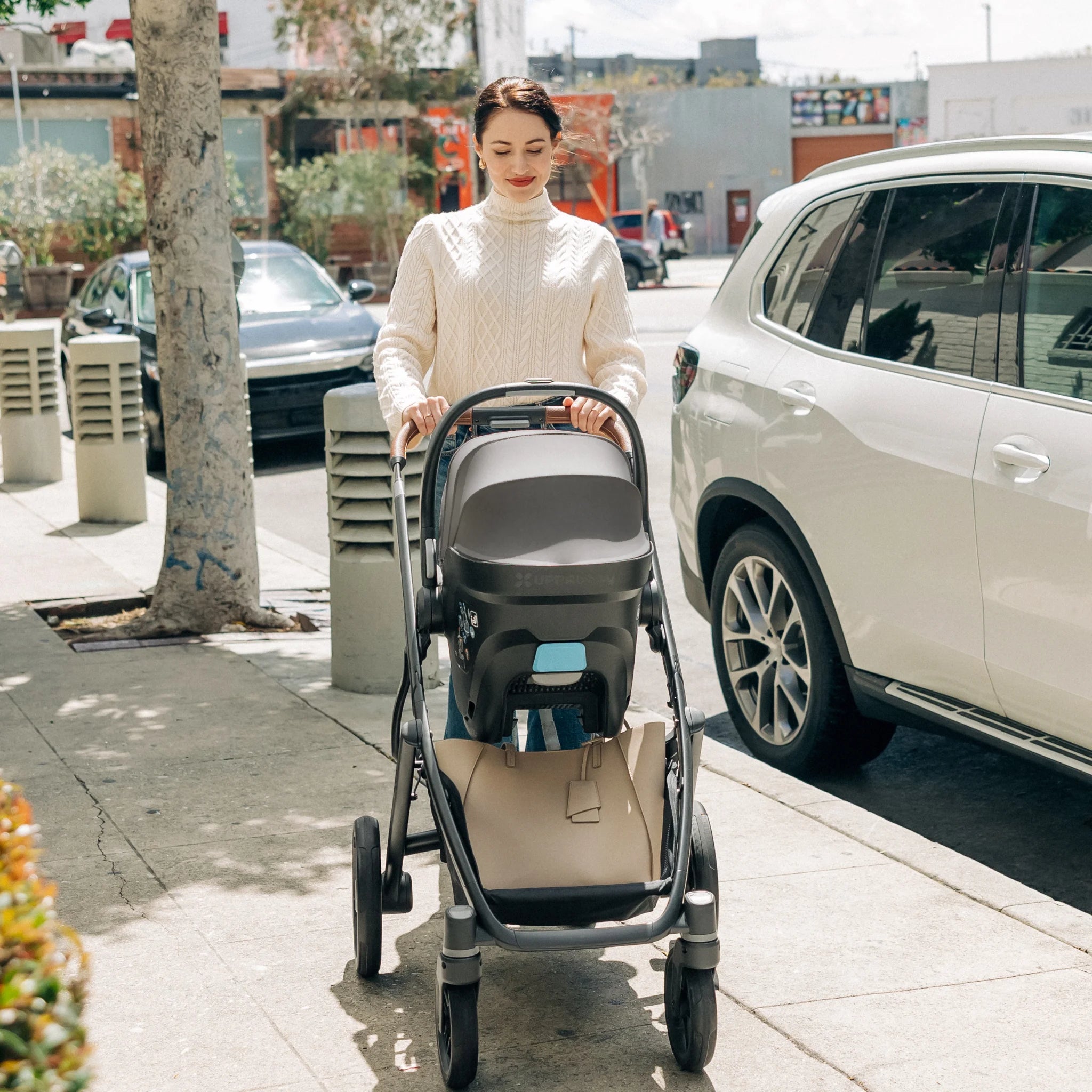 Woman pushing Vista Travel System with the Mesa i-Size infant car seat.