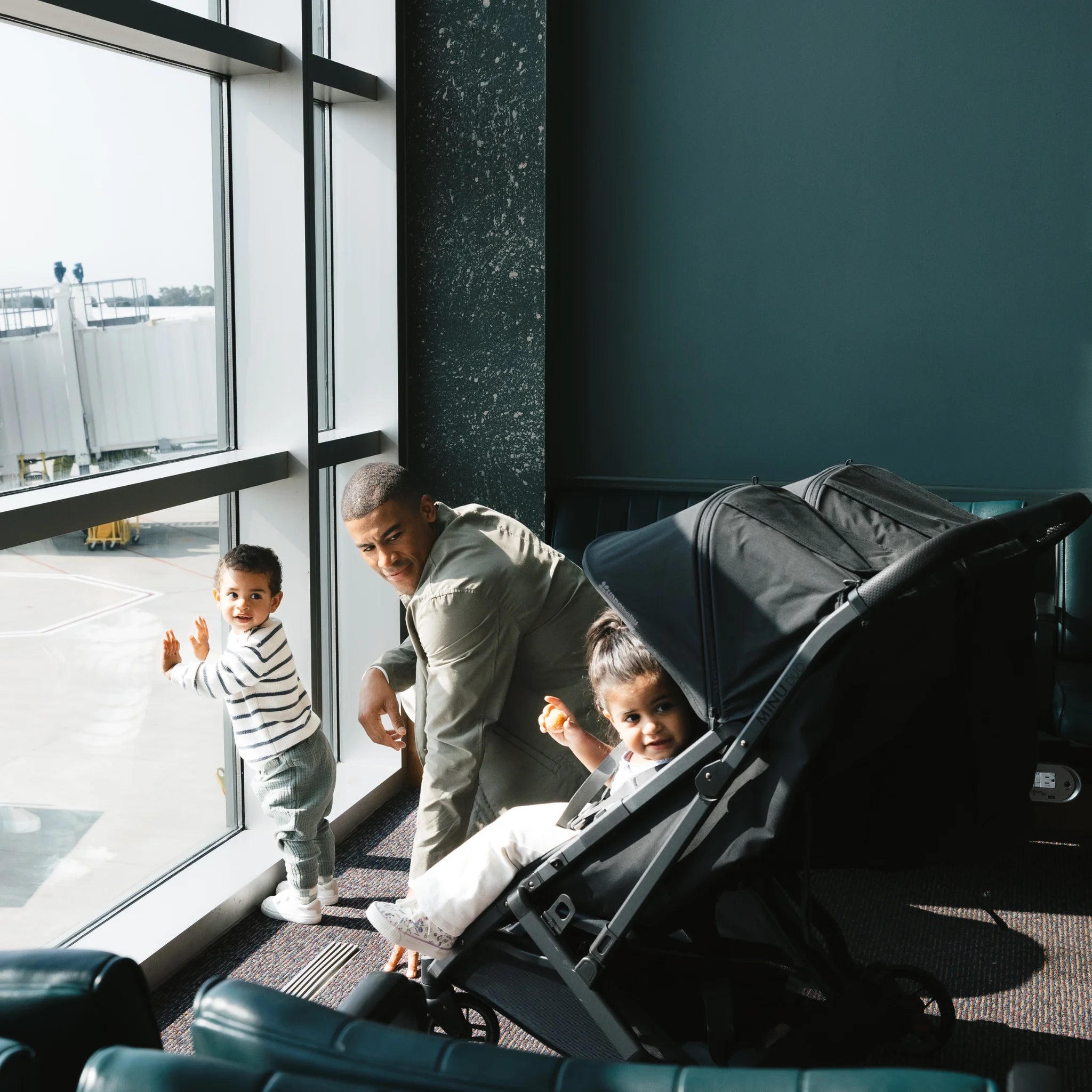 Dad planewatching with toddlers sitting in the Minu Duo pram.