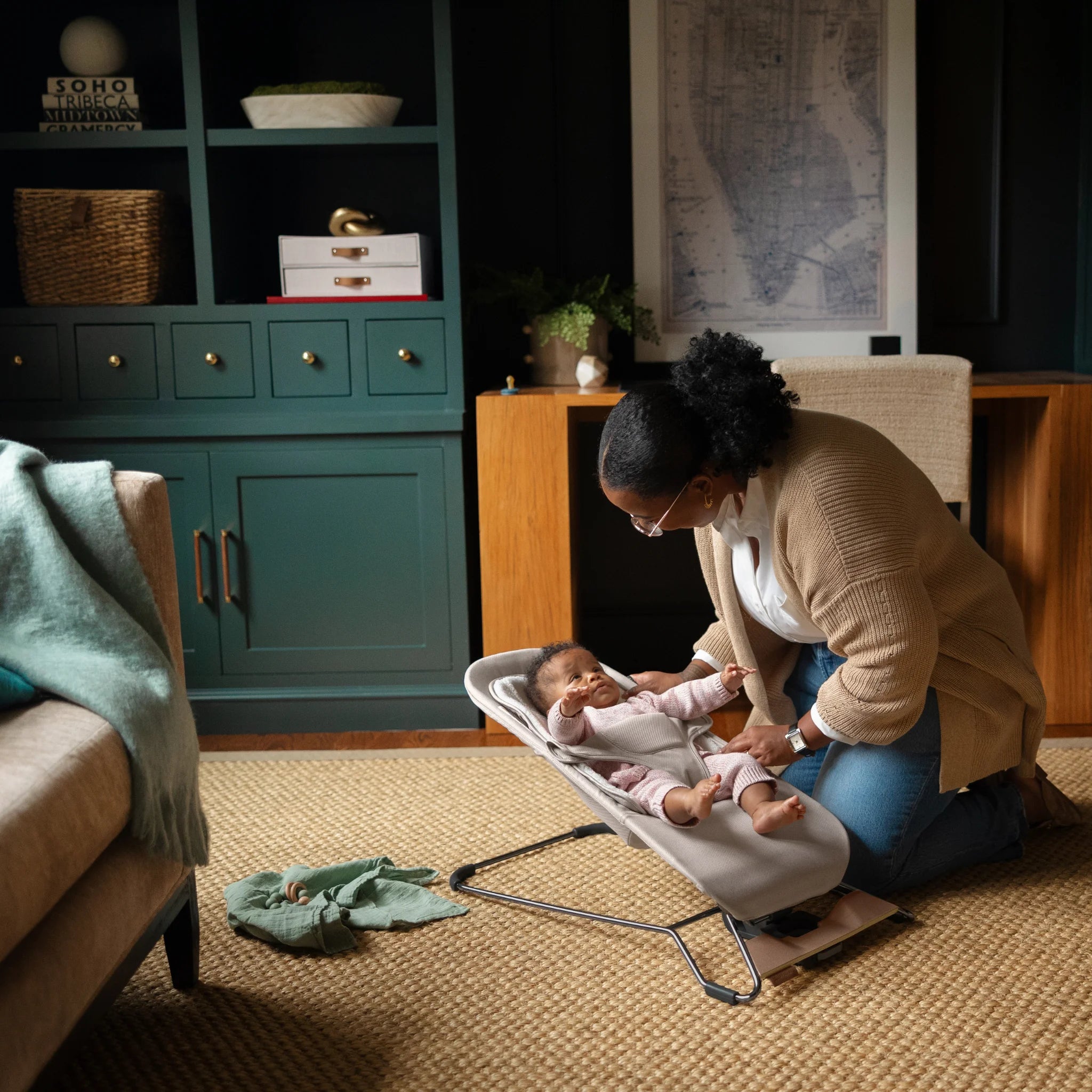Parent adjusting baby in the UPPAbaby Mira baby bouncer in Charlie
