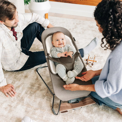Parents playing with baby in the UPPAbaby Mira baby bouncer in Wells