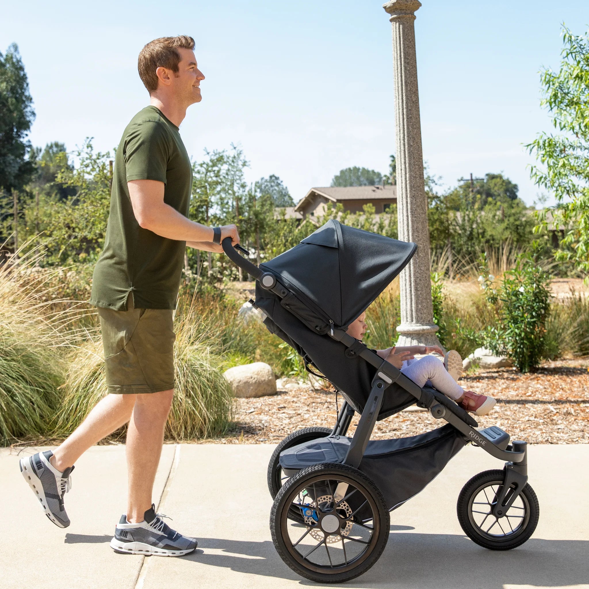 Man jogging with the UPPAbaby Ridge with a child in a park setting