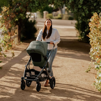 Woman pushing the Evelyn fashion of Vista stroller along a path in a park.
