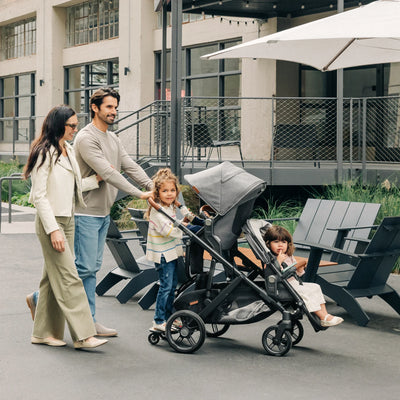 Family with three children on the Vista stroller with expansion accessories.
