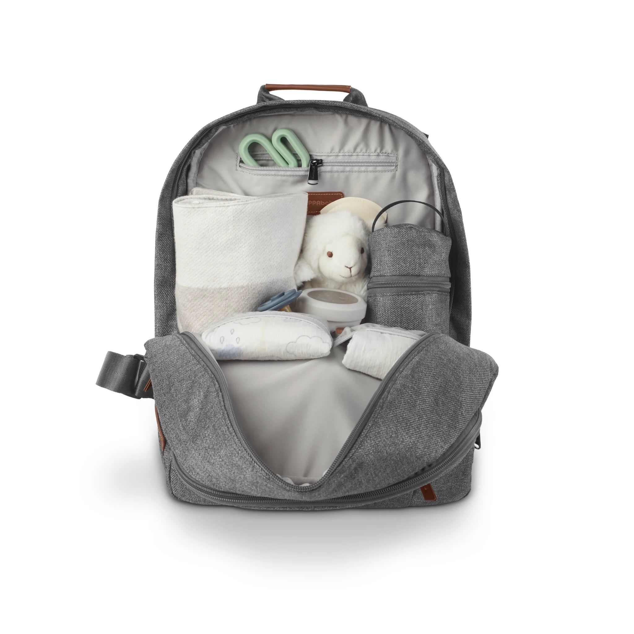 Open Greyson gray changing backpack displayed on a white background, filled with baby essentials including a changing pad, wipes case, bottle holder, toy, and small accessories organized in interior compartments.