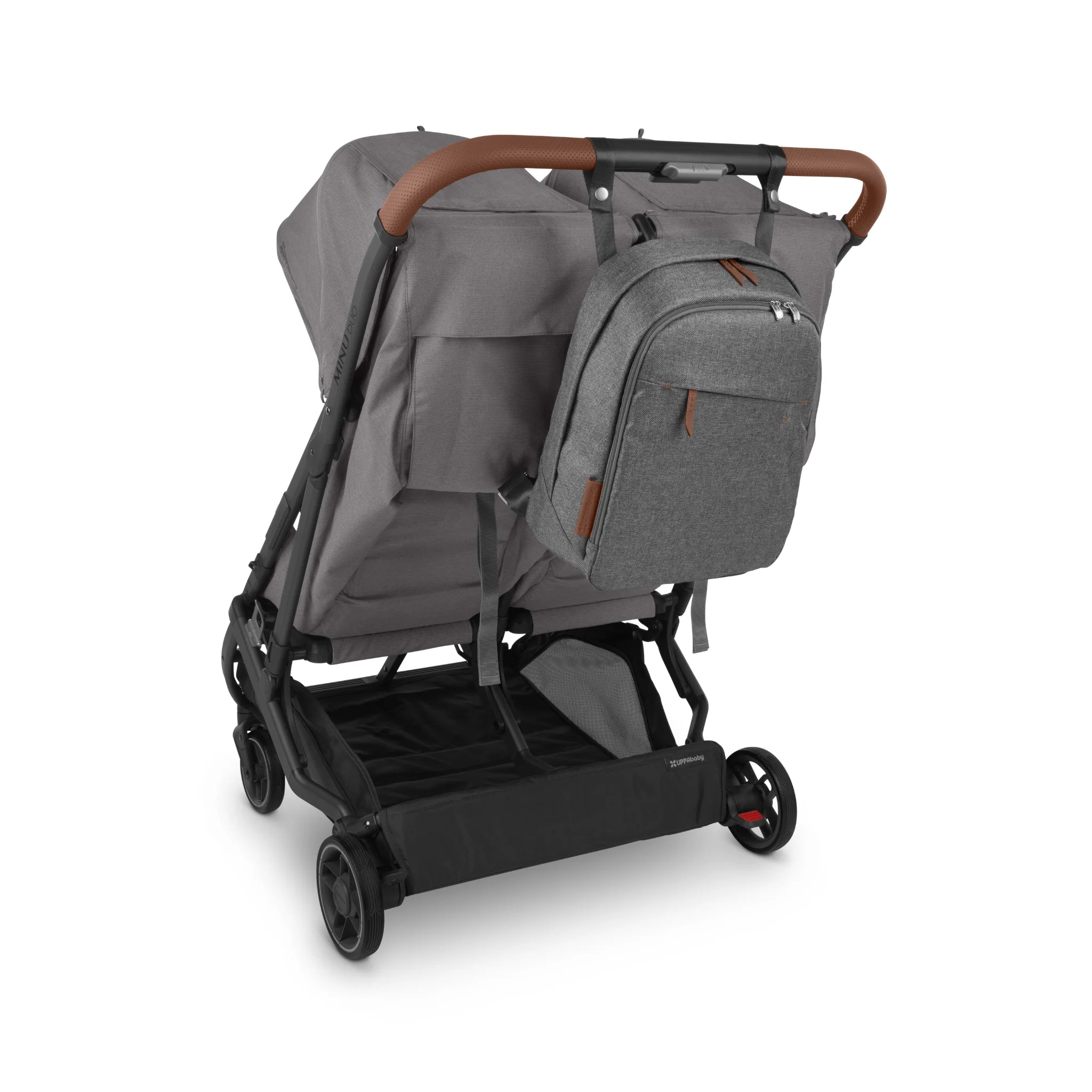 Grey UPPAbaby stroller shown with the matching Greyson changing backpack attached to the handlebar (brown handle accents), on a white background.