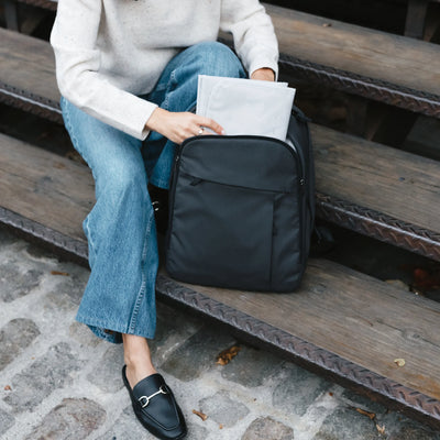 Beige stroller with brown leather accents and a matching beige changing backpack attached, shown on a white background.