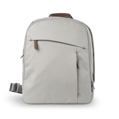 Light gray UPPAbaby changing backpack with brown leather accents, shown upright on a white background.