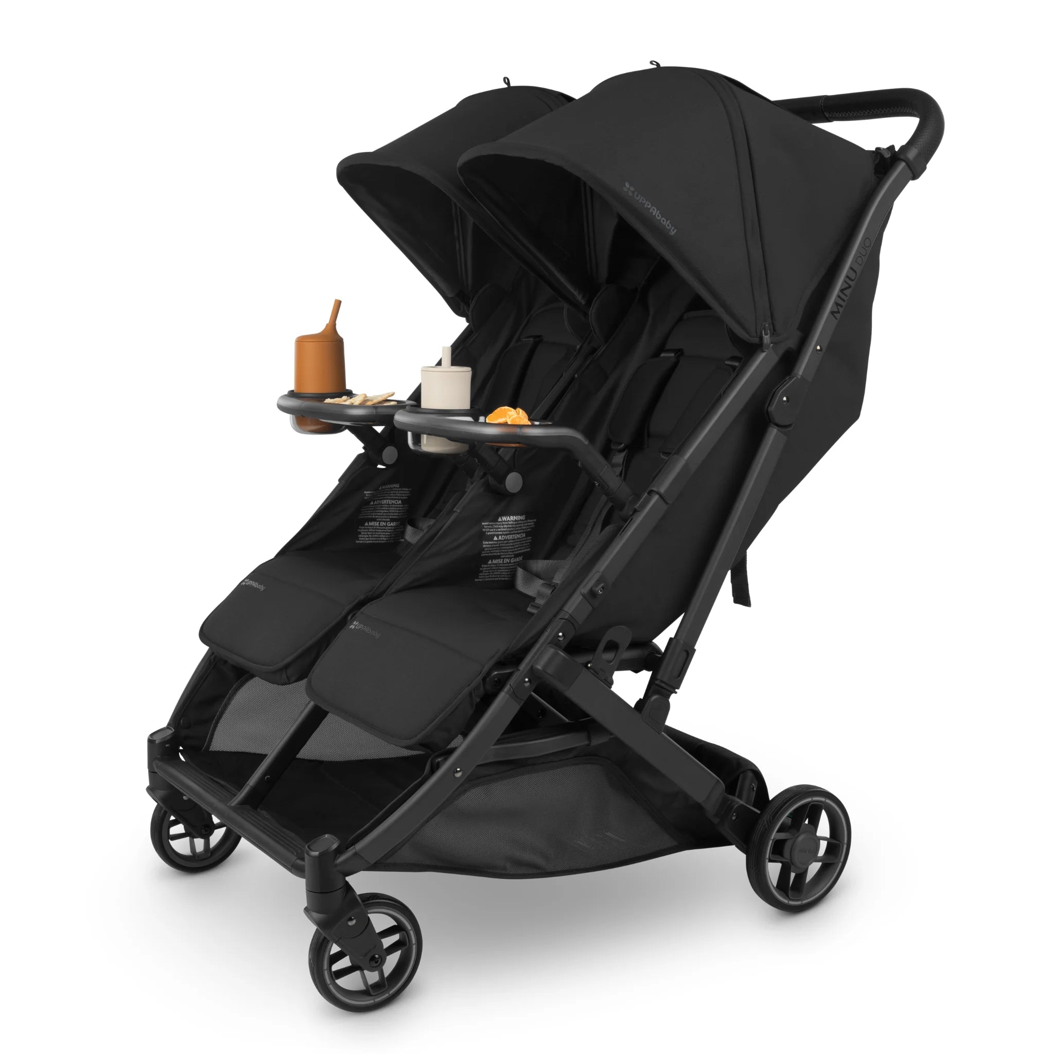 Black UPPAbaby Minu Duo double stroller with snack tray attached, holding cups and snacks, on a white background.