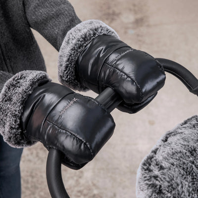 Mum holding stoller handle, with cozy ganoosh luxe on her hands. 