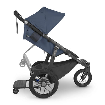 Ridge piggyback board attached to ridge stroller, from a side view, on a white background. 