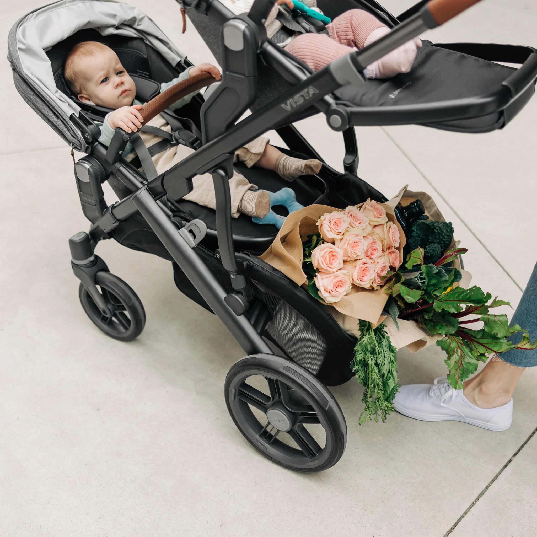 Groceries at the bottom of grey rumbleseat on vista stroller. 