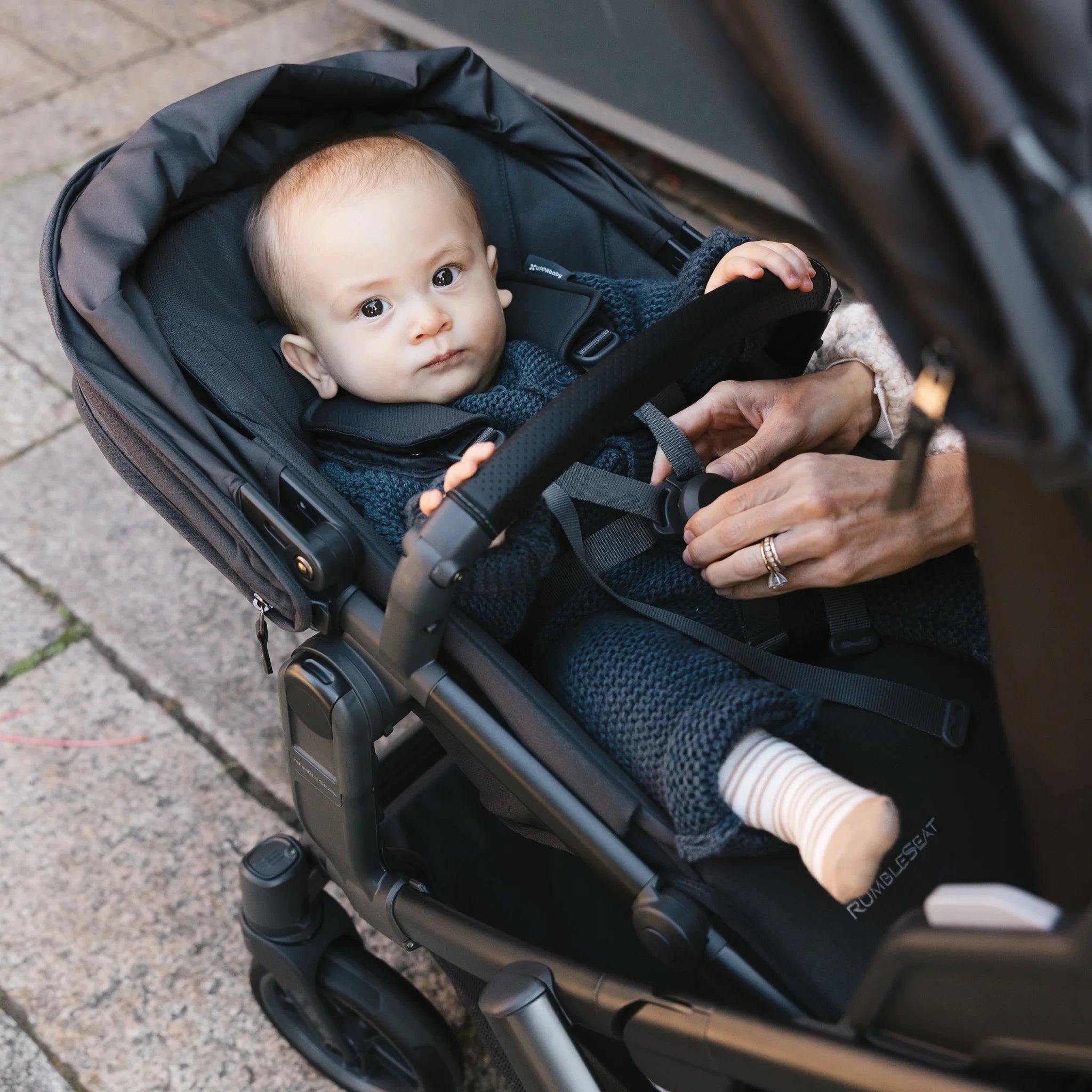 Baby looking straight, from rumbleseat stroller. 