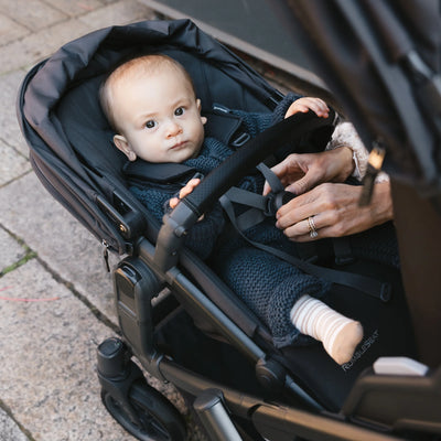 Baby looking straight, from rumbleseat stroller. 