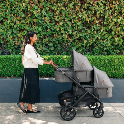 Mum smiling,looking and pushing vista stroller,with vista lower adapters, outside.
